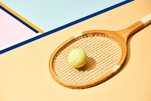 Yellow tennis ball on racket on background with blue lines