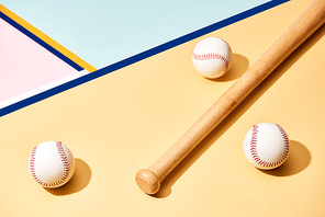 Baseball bat and balls on colorful surface with blue lines