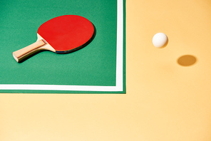 High angle view of tennis racket on table and ball on yellow surface