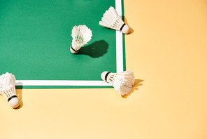 Badminton shuttlecocks on green court and yellow surface