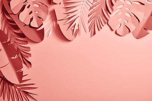 top view of exotic paper cut palm leaves on pink background with copy space