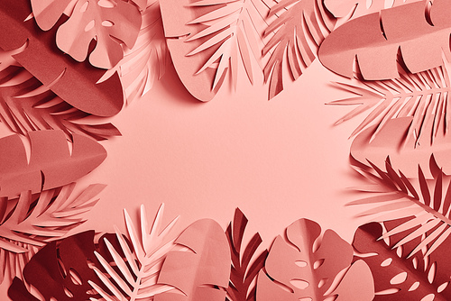 top view of tropical paper cut palm leaves on pink background