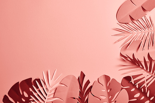 top view of paper cut various palm leaves on pink background with copy space