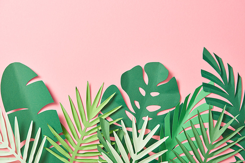 top view of green palm leaves on pink background with copy space