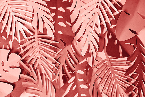 top view of colorful paper cut pink and burgundy palm leaves