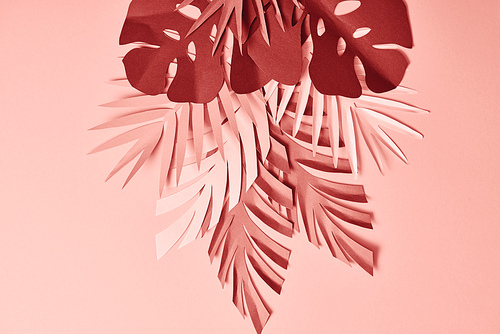 bunch of colorful paper cut palm leaves on pink background
