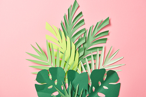 top view of green palm leaves on pink background with copy space