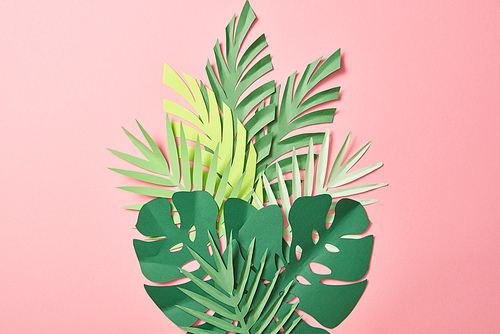 top view of green palm leaves on pink background with copy space