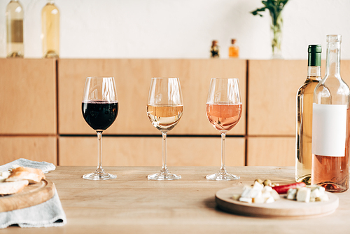 wine glasses, bottles and food on wooden table