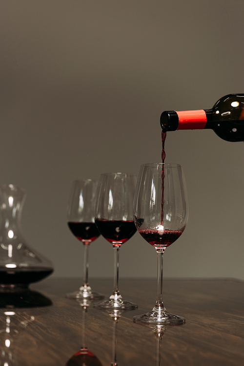red wine pouring in wine glasses from bottle in restaurant