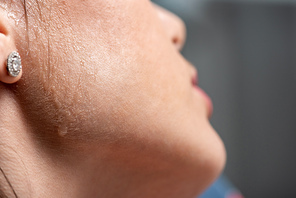 cropped view of young woman with sweat on face suffering from heat on grey