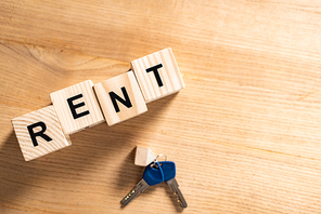 top view of keys with key chain near wooden cubes with rent lettering on table