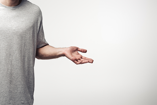 cropped view of man showing shrug gesture isolated on grey, human emotion and expression concept