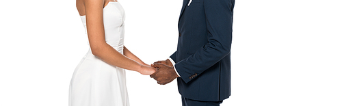 panoramic shot of african american bridegroom and bride holding hands while standing isolated on white