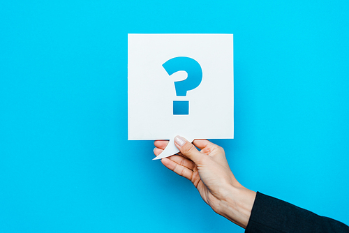 cropped view of woman holding speech bubble with question mark on blue
