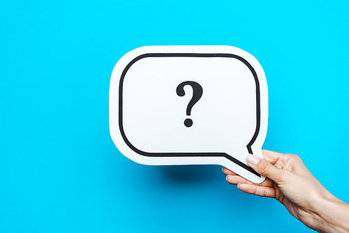 cropped view of woman holding white speech bubble with question mark on blue