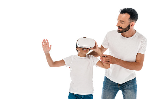 smiling father standing with happy kid in virtual reality headset isolated on white