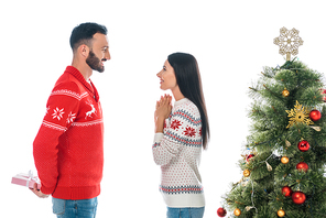 happy bearded man holding gift near woman and christmas tree isolated on white