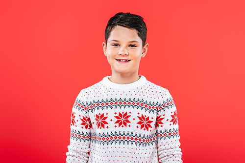 front view of smiling kid in sweater isolated on red