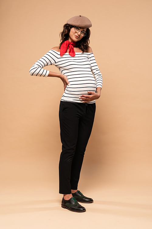 pregnant french woman in beret  on beige background