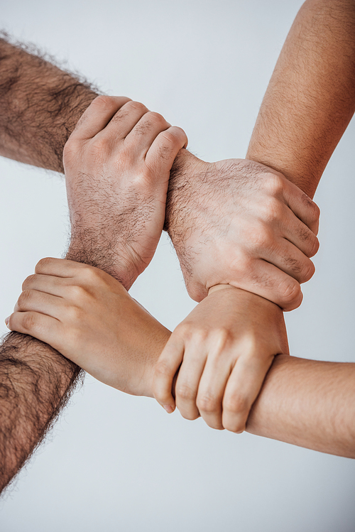 Cropped view of men doing unity gesture with hands isolated on grey