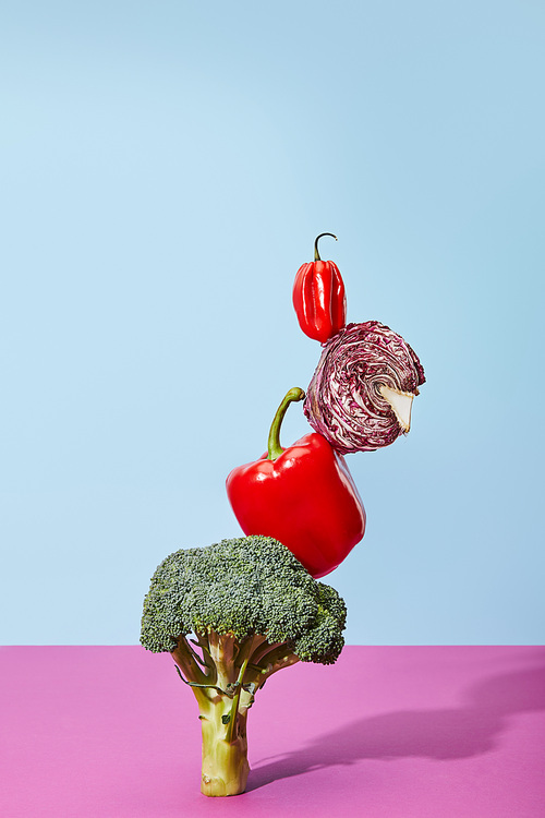 habanero, red chinese cabbage and bell pepper on broccoli on blue and pink