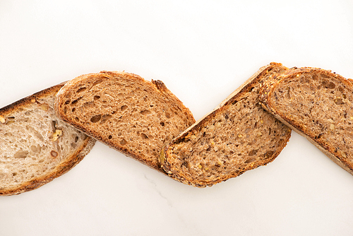 top view of whole grain bread slices on white background
