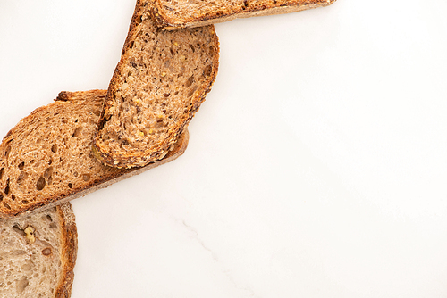 top view of whole grain bread slices on white background with copy space