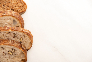 top view of fresh whole wheat bread slices on white background with copy space