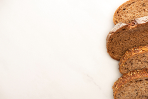 top view of fresh whole wheat bread slices on white background with copy space