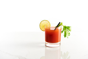bloody mary cocktail in glass garnished with lime and celery isolated on white