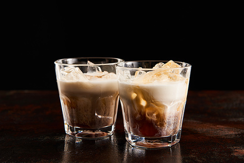 fresh white russian cocktail in glasses isolated on black