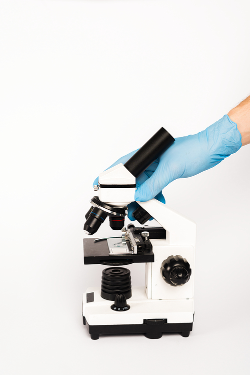 cropped view of scientist touching microscope isolated on white