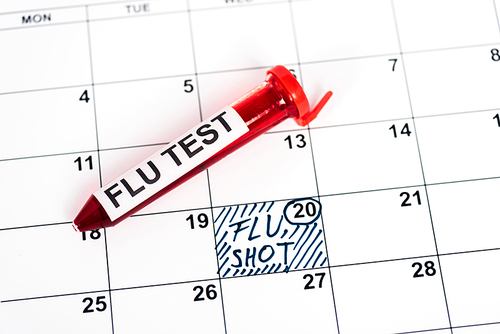 sample with flu test on calendar with marked date and flu shot lettering