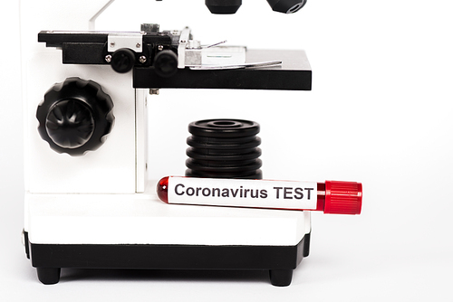 microscope and sample with coronavirus test lettering on white