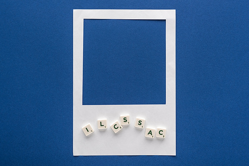 top view of letters on cubes and white photo frame on blue background