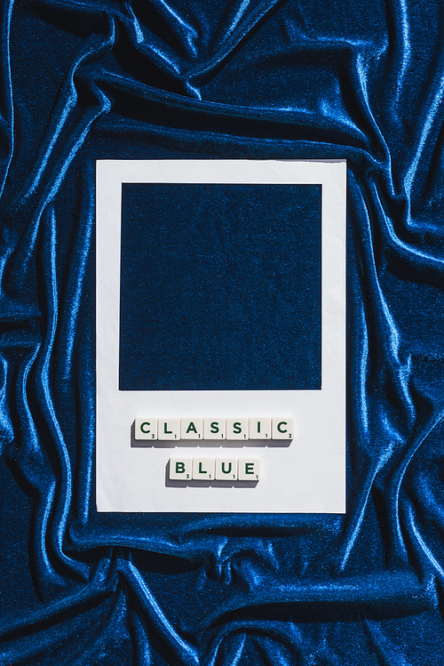top view of classic blue lettering on cubes and white photo frame on blue velour cloth