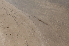 brown textured surface with sand and water with copy space