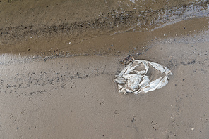 top view of plastic bag in wet sand