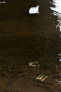 plastic garbage on textured sandy bottom in river