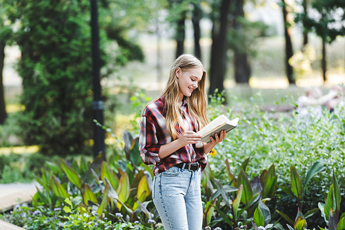 beautiful girl in casual clothes smiling while reading book