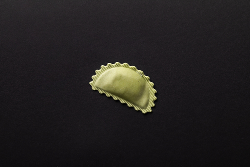 top view of green stuffed ravioli isolated on black with copy space