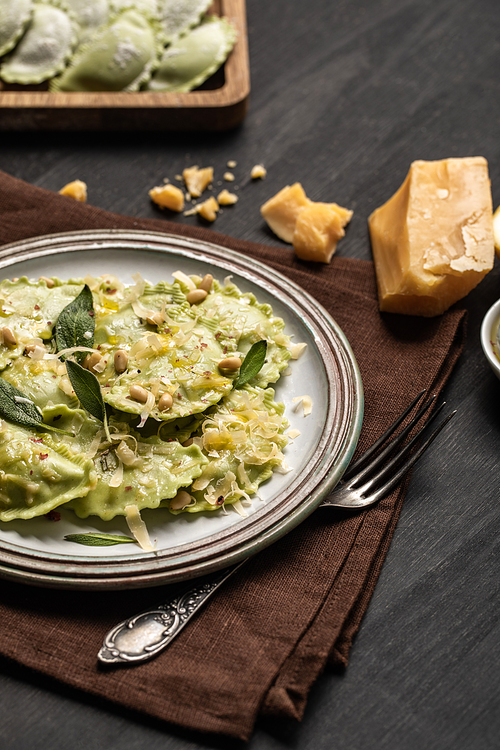 delicious green italian ravioli with pine nuts, sage and melted cheese served on table