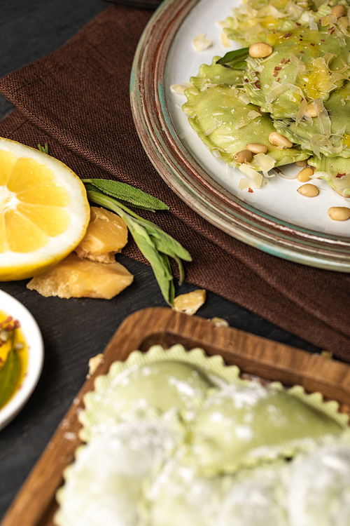 selective focus of green delicious ravioli with pine nuts on plate