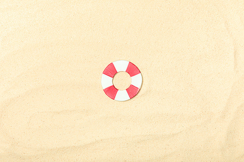 top view of paper beach with lifebuoy on textured sand