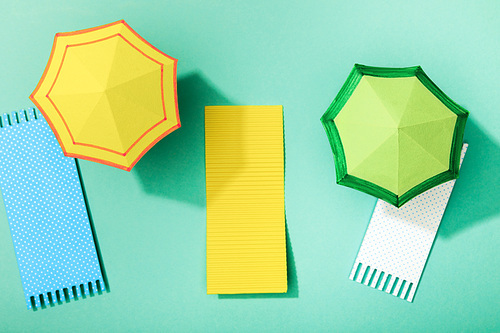 top view of paper towels and umbrellas on turquoise background