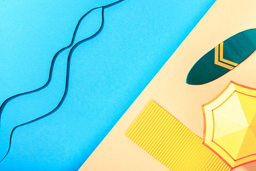 top view of paper blue sea with waves near shore with surfboard, towel and umbrella