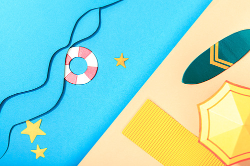 top view of paper blue sea with waves and lifebuoy near shore with surfboard, towel and umbrella