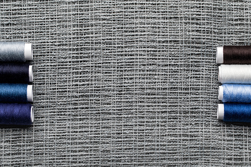 top view of blue and grey cotton thread coils on sackcloth with copy space