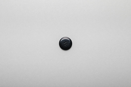 top view of black clothing button isolated on grey with copy space